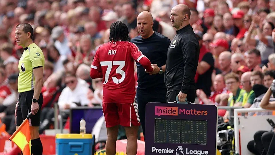 Rio Ngumoha of Liverpool interacts with Arne Slot