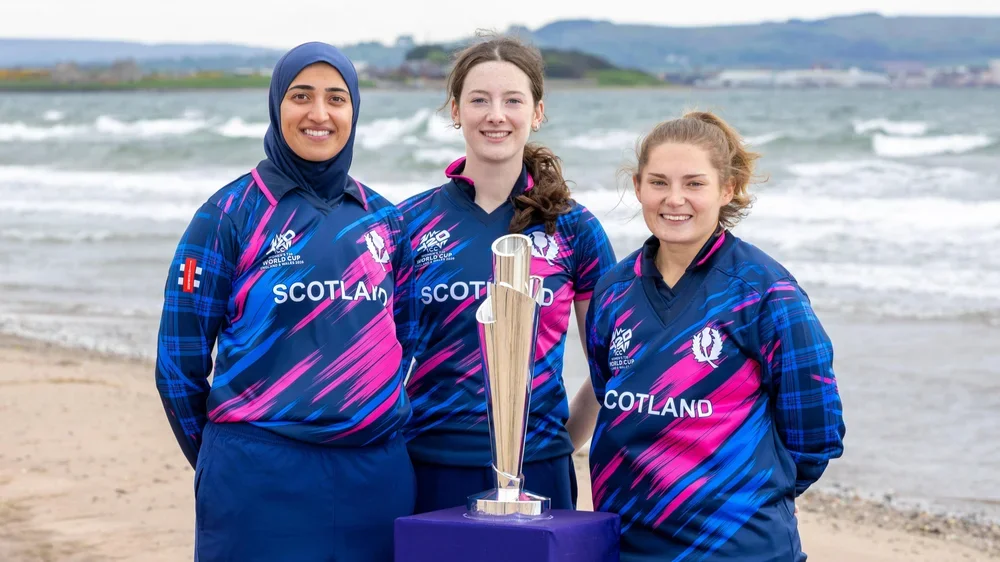 Scotland players Abtaha Maqsood, Gabriella Fontenla and Megan McCall pose with the World Cup trophy at Prestwick beach